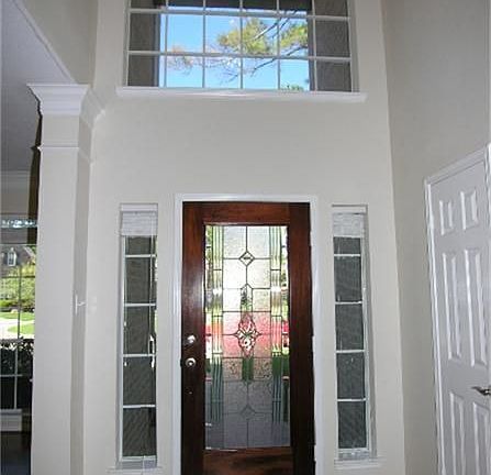 Impressive entry with Richly Stained Leaded Glass door, Hardwood Flooring, freshly painted, Updated Iron lighting.