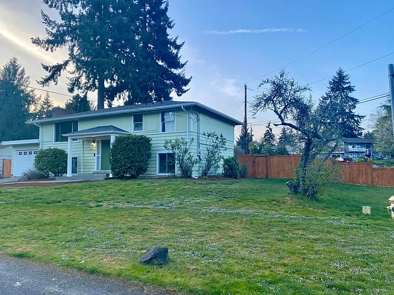 Side of house huge yard and lots of parking for RV or extra vehicles behind gated fenced yard.