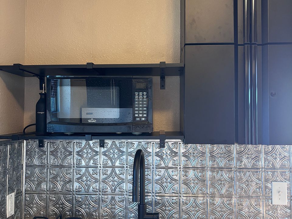 Microwave and gas cooktop in kitchen.