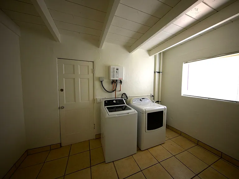 Laundry room with washer/dryer, whole-house on-demand electric water heater, and a lot of shelves for storage (not shown)