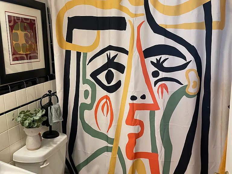 Bathroom with a tub and shower. The floors and wall tiles are classic original. We loved them so when we renovated we removed the drywall from the back bedroom to replumb.