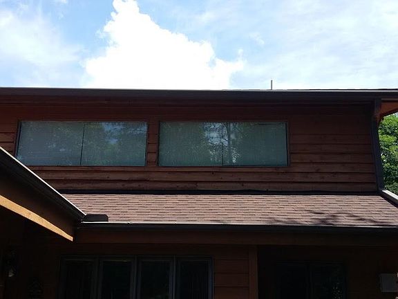Left window is over kitchen counter, Right window is in Living room, both overlook the pretty yard and tree lined edge of yard. Large eve overhang shades windows in the summer, shines in/adds heat in the winter.
