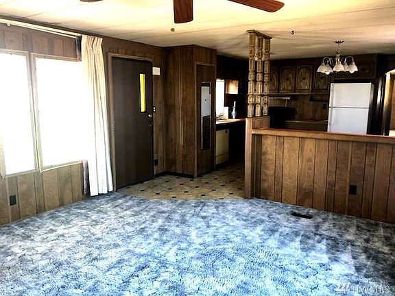 Living room and kitchen standing in corner by book shelf.
