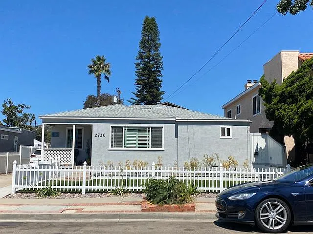Front of home with fenced front yard and patio furniture