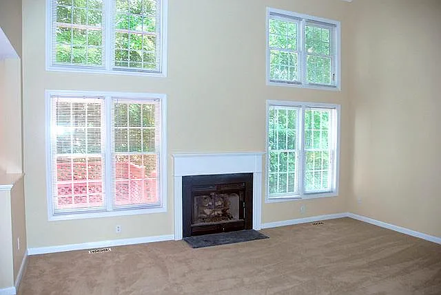 Living room with beautiful bright windows and views. Gas log fireplace