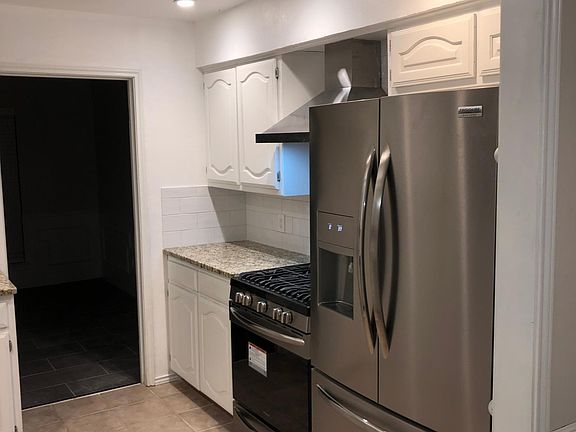 Kitchen contains stainless sink with single handle pull down faucet, stainless dishwasher, gas range, and garbage disposal. The kitchen area also has a separate pantry and small breakfast eating area not shown in current photo.