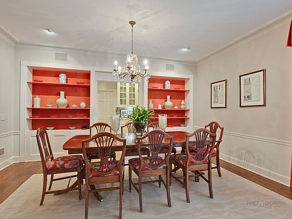 The dining room sparkles with a crystal chandelier and built-in shelving
