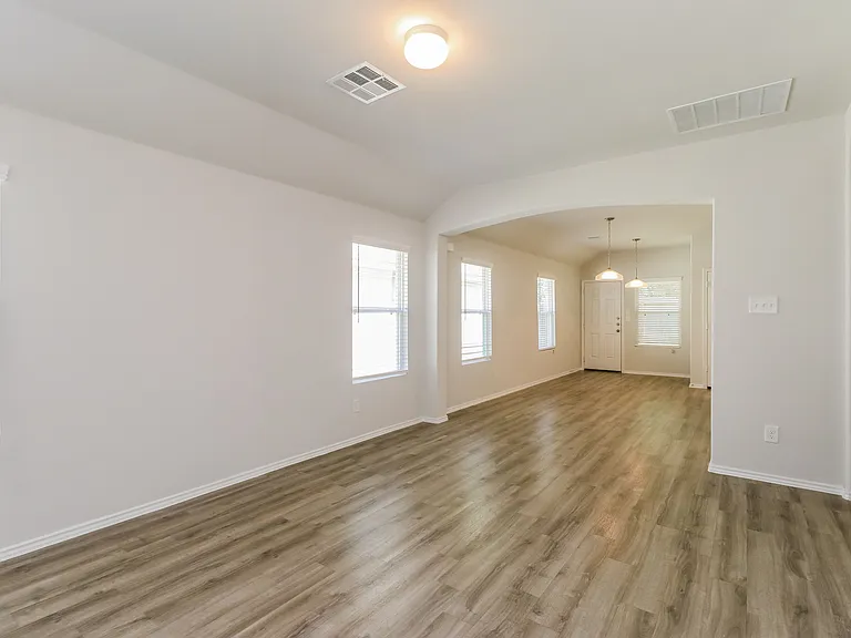 Spacious open-concept living area with elegant wood flooring and abundant natural light. Spacious open-concept living area with elegant wood flooring and abundant natural light.
