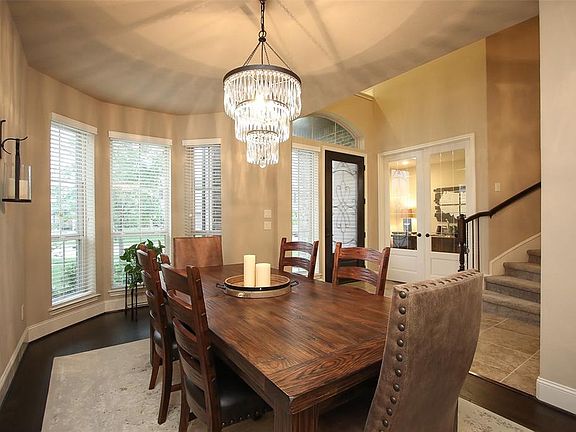 The open and elegant dining room has rich hardwoods an elegant Pottery Barn chandelier.