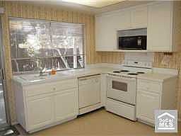 Sunny kitchen that has sliders to the backyard