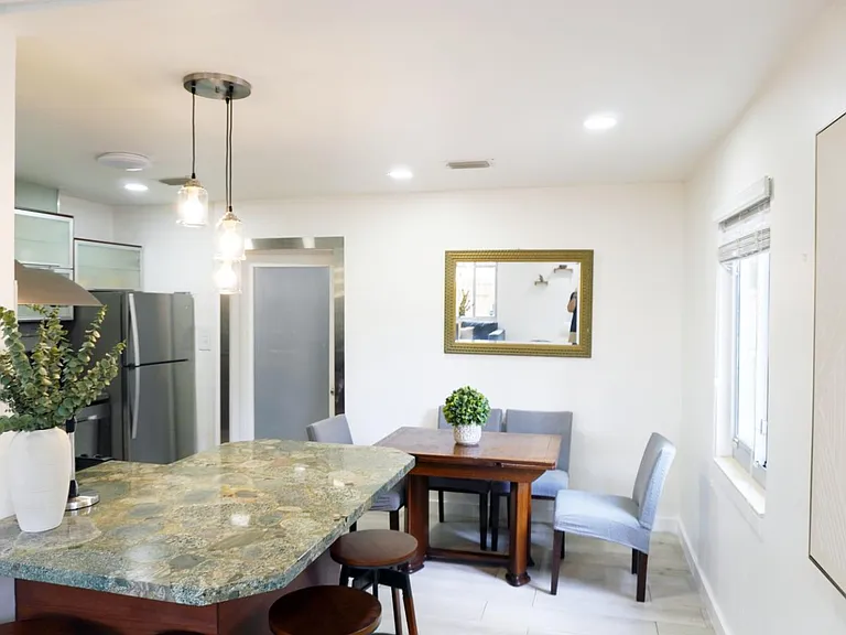 Dedicated dining nook with a four-seat table, adjacent breakfast bar, pendant lighting, and nearby kitchen access.