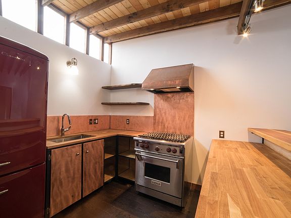 Wolf stove Copper backsplash and hood Red Chambers fridge Butcher block countertops and buffet/bar with lots of storage