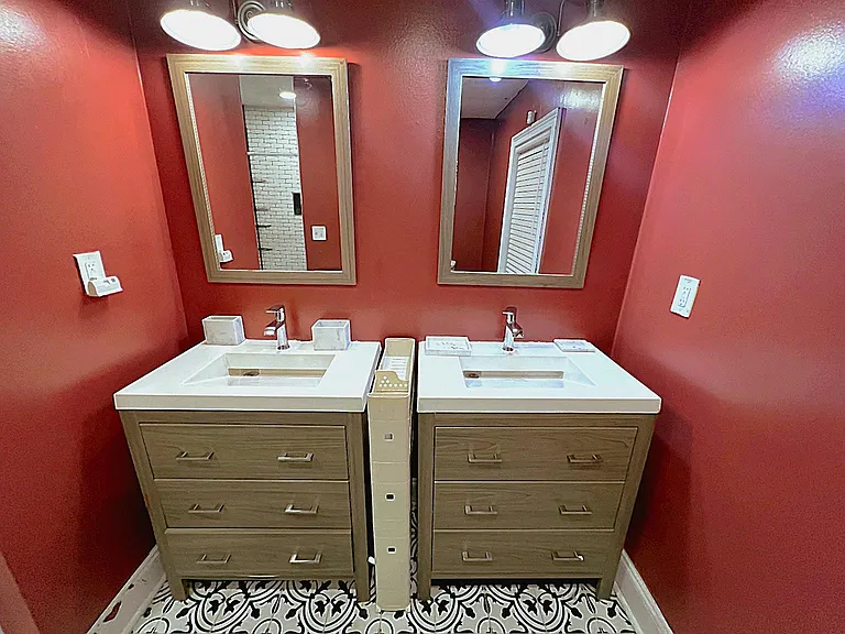 Double-vanity bath with two sink stations, ample drawer storage, and decorative tile flooring for easy daily routines.
