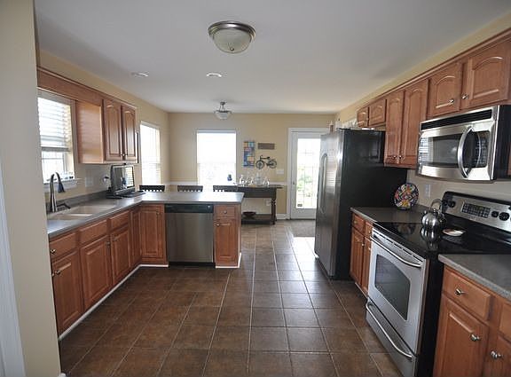 Kitchen with stainless steel appliances, corian counters & tile floors