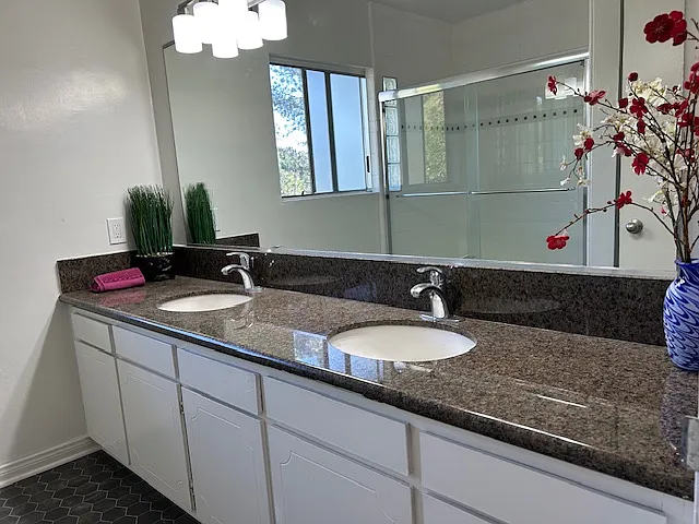 Lower level bathroom. Double sinks set in solid granite. This huge full bath accomodates both downstairs bedrooms with extra space.