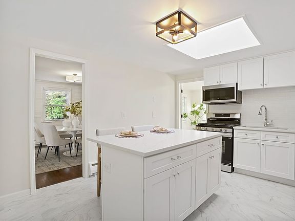 Brand-new skylights flood this upgraded modern kitchen with light, creating a bright and welcoming breakfast bar.