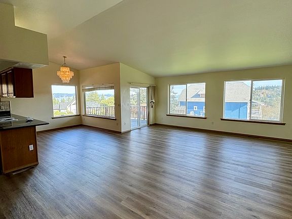 Main living area with lots of windows and a slider leading to the deck.