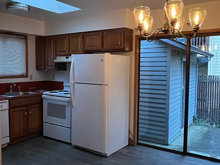 Kitchenette view with slider door. Large shed in photo. Access from kitchen slider door