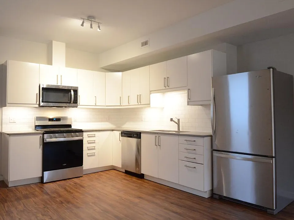 Well-appointed open kitchen. (quartz counters, subway tile back splash, stainless steel appliances)