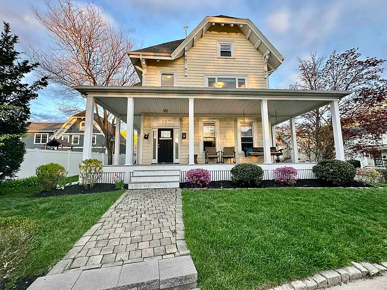 Charming Melrose home with welcoming front porch, landscaped yard, and warm evening curb appeal.