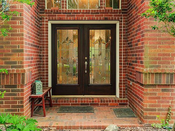 Stunning brick home with covered front porch, double doors and lots of windows.