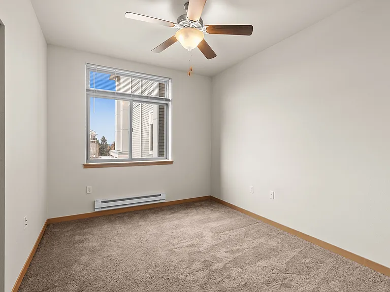 Bright and airy room with a large window view, modern ceiling fan, and plush carpet flooring, ready for your personal touch. Bright and airy room with a large window view, modern ceiling fan, and plush carpet flooring, ready for your personal touch.