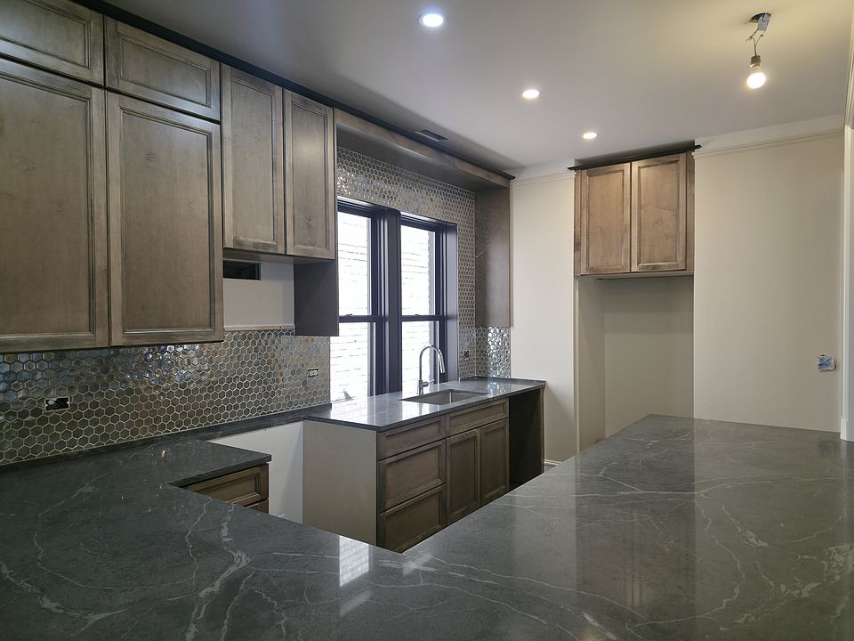Kitchen with rich toned cabinets, quartz countertops and backsplash! (Appliances coming)