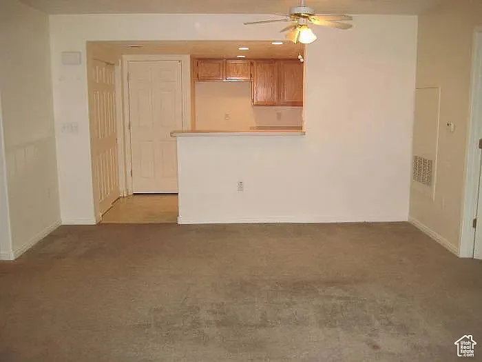 Unfurnished living room featuring a ceiling fan, light colored carpet, and recessed lighting
