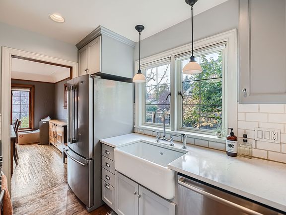 Sunny kitchen with stainless French door refrigerator & farm sink