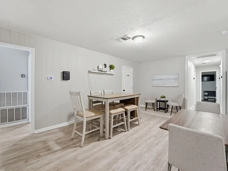 Open dining area with a high-top table, bar seating, and easy flow into nearby rooms for shared meals and gatherings.