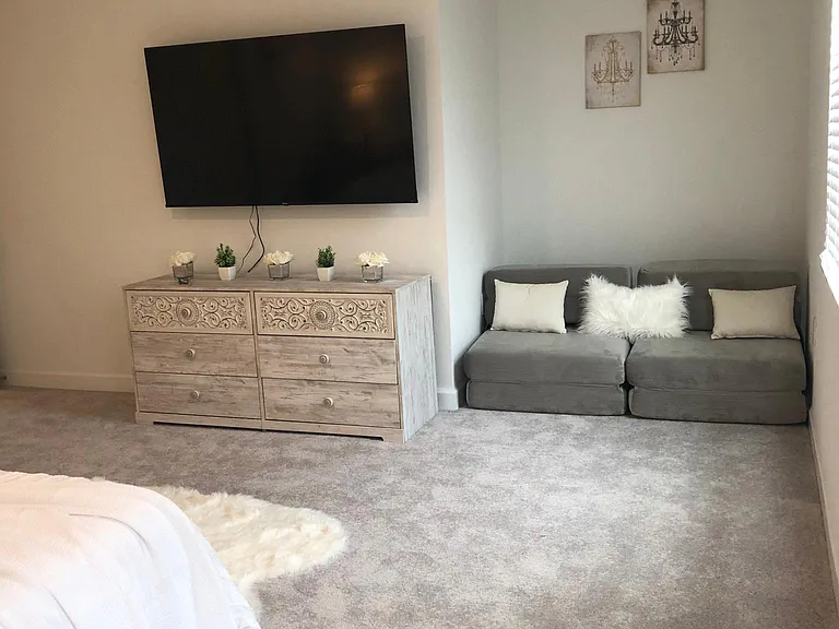 Big TV and a dresser in the primary bedroom, and folding sofa to sit or to sleep 2 extra people