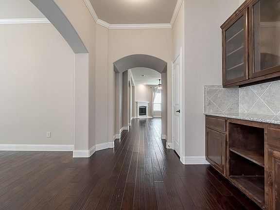 Hallway from the front door. dinning room is on the left and right with dinning room cupboard and storage