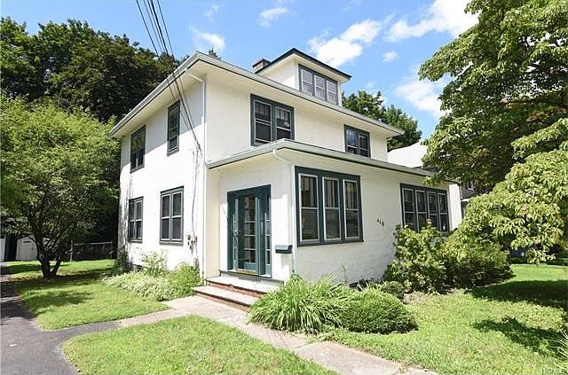 View of stucco home.  Door to enclosed small entrance porch with closet.