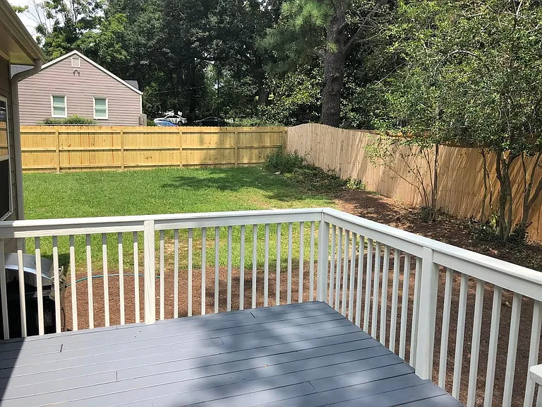 Deck leading into fenced backyard.