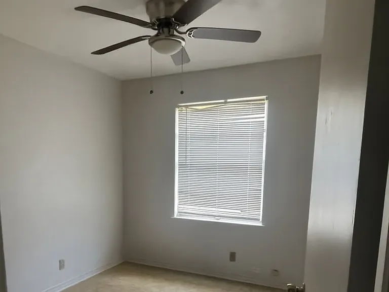 Comfortable second bedroom with durable flooring, a ceiling fan, and a bright window. Perfect for a guest room, child's room, or home office.