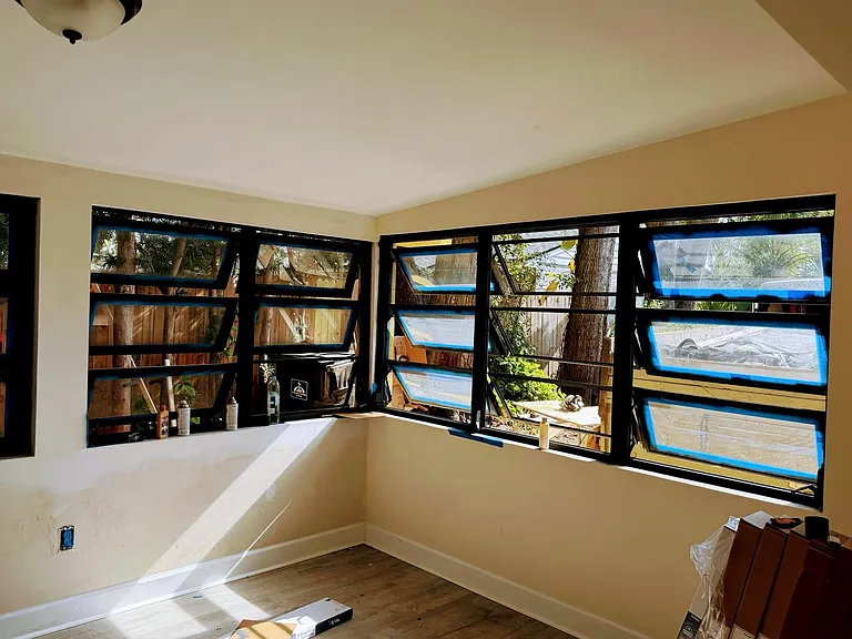 Sunny and spacious living room. This picture shows the windows being newly painted. New blinds also.
