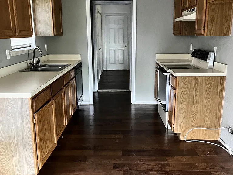 New double door refrigerator being installed. Laundry hook ups are between kitchen and small extra room.