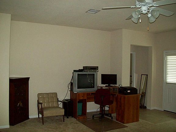 Family room has nice ceiling fan and lots of windows