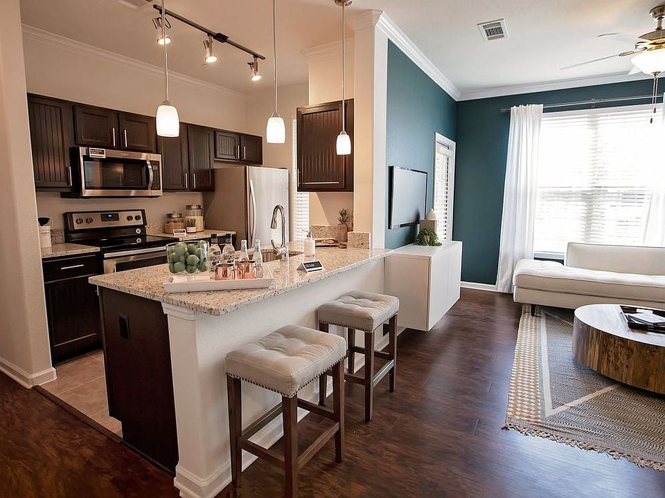 Kitchen with espresso cabinetry, granite countertops, stainless steel appliances, and tile flooring