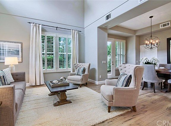 Formal light living room with high vaulted ceilings, new contemporary white linen drapes, fresh Benjamin Moore gray paint.