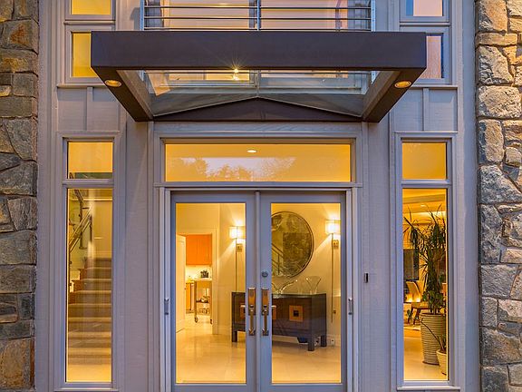 Full stone walls w/glass canopy entry+steel railing