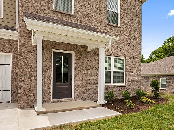 Enjoy a charming front porch and professional front yard landscaping.