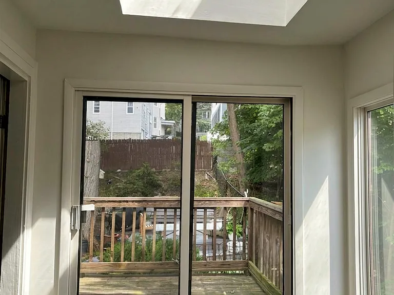 Sitting area as seen from kitchen. Seamlessly continues into a deck that overlooks the backyard. Huge skylight above sitting area.