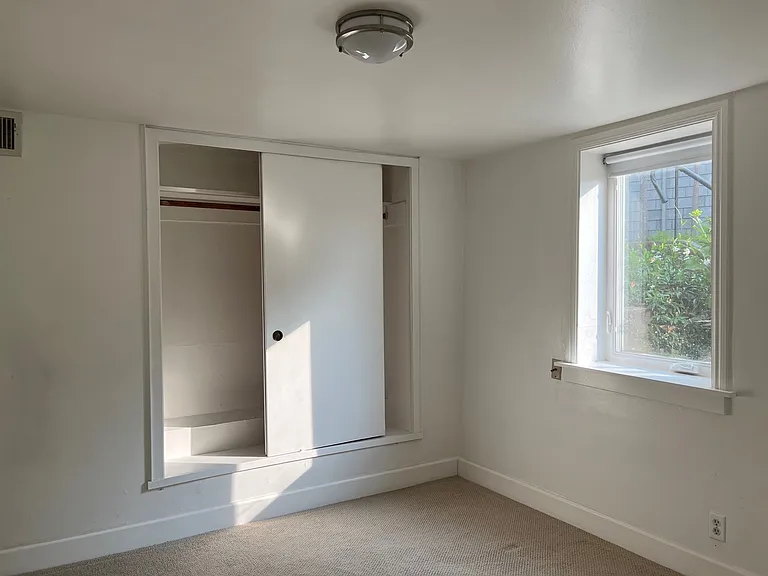 bedroom toward a closet and the window