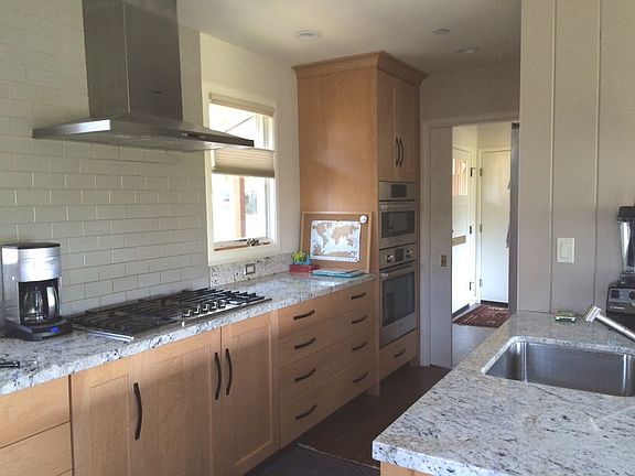 Kitchen features granite counters and lower cabinets with pu