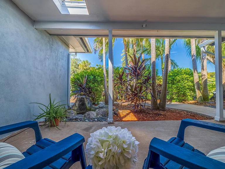 Serene setting on front porch with palm trees and water fountain!