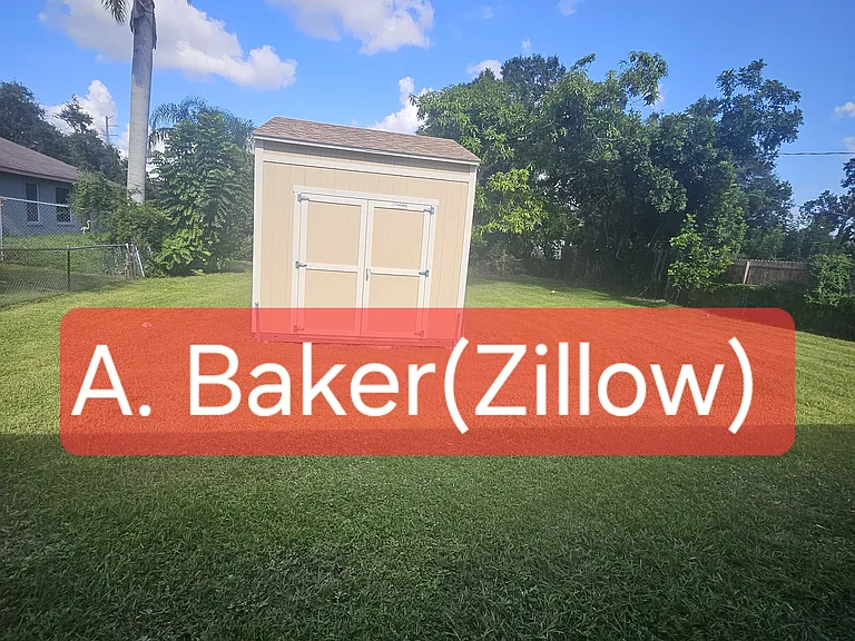 Large fenced in backyard with detached storage unit