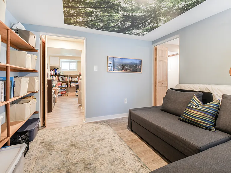 Basement guest room from northeast corner with ceiling mural of tree canopy.