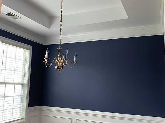 Dining room with tray ceiling and wanscoting