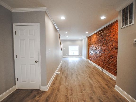 Walk in to an open first level with exposed brick in the living space